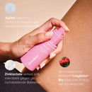 Mensch sprüht Intimate-Refreshment-Spray auf das Bein, mit Textfeldern.