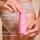 Mensch hält Intimate-Refreshment-Spray vor den Körper, mit Textfeldern.