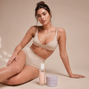 Woman in beige underwear sitting next to the Touch Me Duo with scrub and Dry Touch Body Oil, juno&me