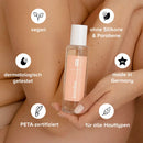 Person hält Dry-Touch-Body-Oil vor den Arm, mit Informationstext.