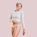 Smiling woman with grey hair in a white long-sleeve top and the Incontinence Panty Medium Nude