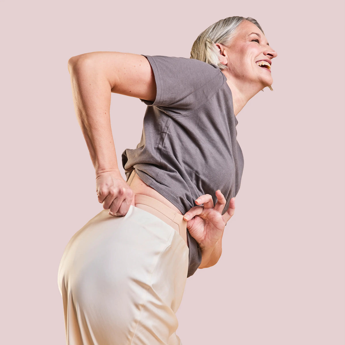 Laughing woman in a grey top wearing the Incontinence Panty Strong in nude