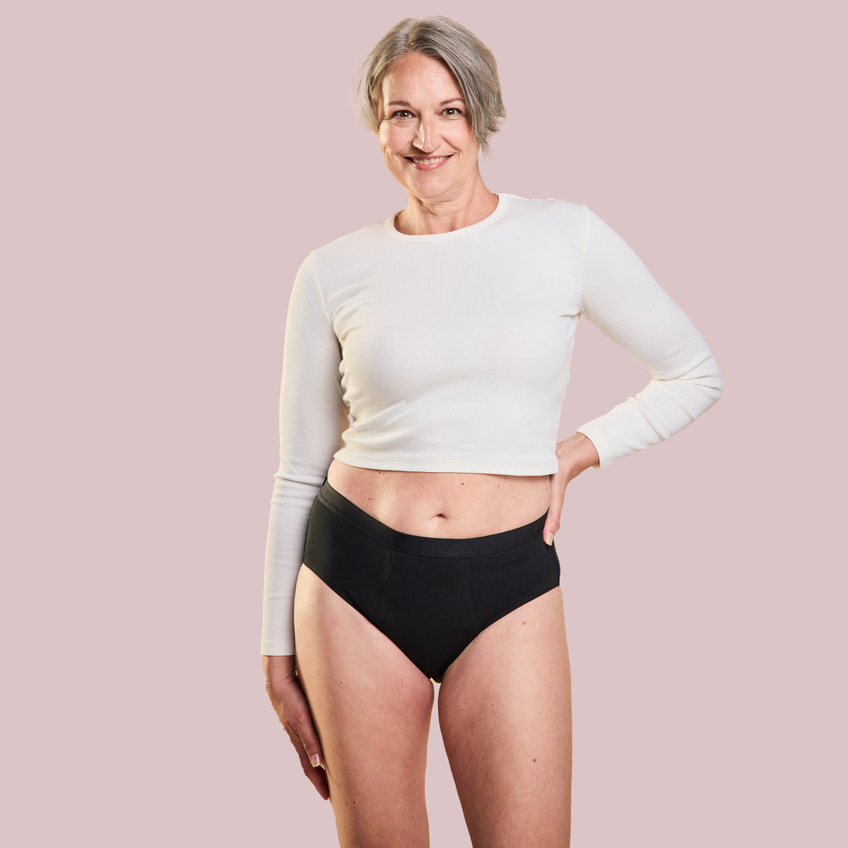 Frau trägt schwarze Periodenunterwäsche Inkontinenz-Panty-Strong mit sportlichem Oberteil.