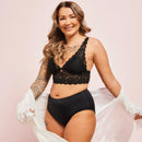 Frau trägt schwarze Periodenunterwäsche Seamless-High-Waist mit spitzen BH und lächelt.