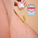 Glow Below Oil from the Glow Below Duo dripping onto skin, with the German Dermatest seal "sehr gut"