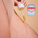 Glow Below Oil dripping from the pipette onto skin, next to the German Dermatest seal "sehr gut" 2024