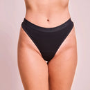 Schwarzer ribbed panties wird von Person getragen, mit neutralem Hintergrund.