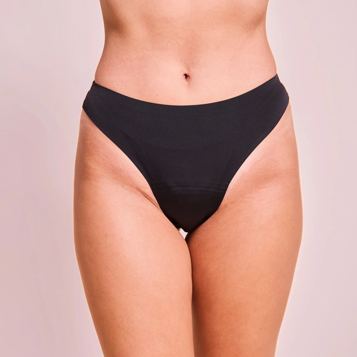 Black seamless panty worn by a person against a neutral background.