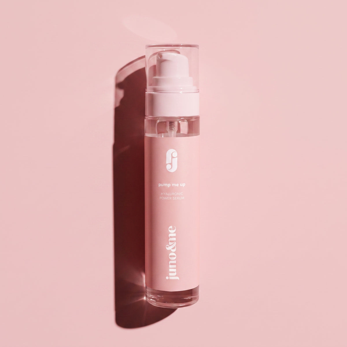 Décolleté Serum with Hyaluronic Acid by juno&me against a pink background